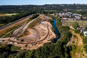 large back hoe moving a mound of dirt
